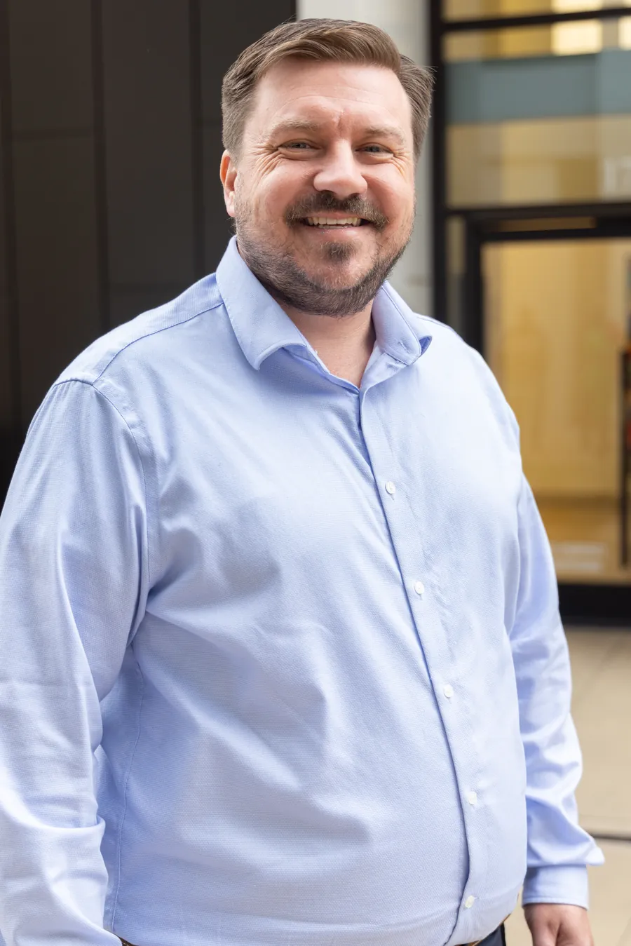 Josh Wile, counselor, standing in a light blue shirt